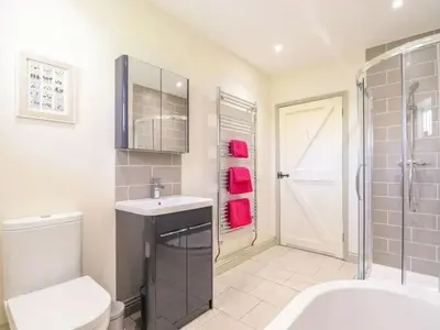 a bathroom with a sink and a toilet and a shower at Hideaway Barn in Germoe