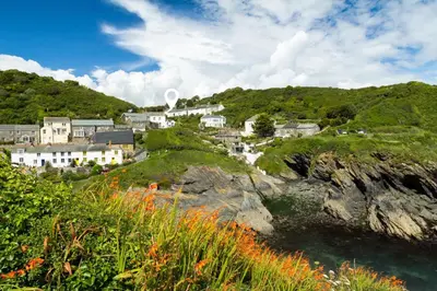 a group of houses on a hill next to the water at Coastguard Cottage - set in an elevated position with fabulous views overlooking Portloe in Portloe