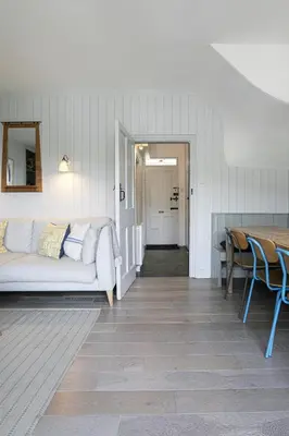 a living room with a couch and a table at Coastguard Cottage - set in an elevated position with fabulous views overlooking Portloe in Portloe