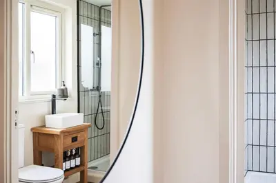 a bathroom with a sink and a mirror at Longstone at Bogee Farm in Saint Ervan