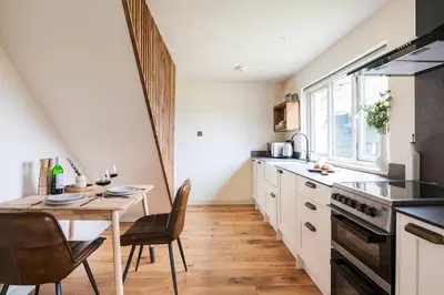 a kitchen with a table and chairs and a dining room at Longstone at Bogee Farm in Saint Ervan