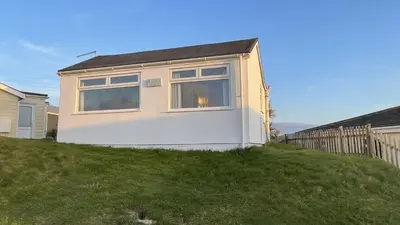 a house sitting on top of a grassy hill at E42 Vista Marina, Riviere Towans in Hayle