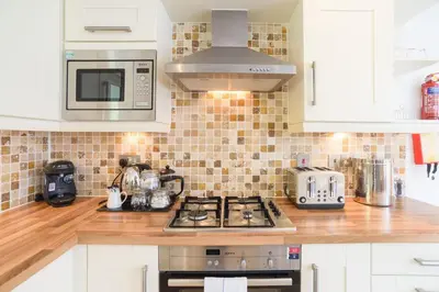 a kitchen with a stove and a microwave at Trewhiddle Cottage 41 - 1 Bedroom Cottage in St Austell