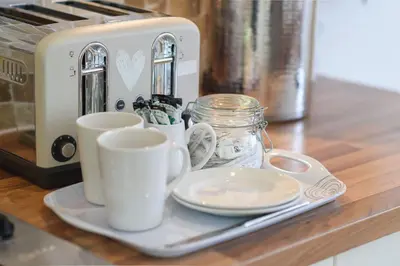a counter with two cups and a toaster and plates at Trewhiddle Cottage 41 - 1 Bedroom Cottage in St Austell