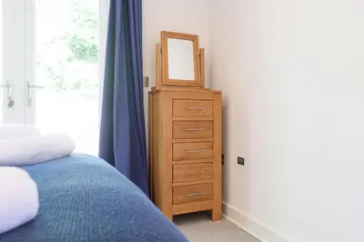 a bedroom with a dresser with a mirror on it at Trewhiddle Cottage 41 - 1 Bed Ensuite in St Austell