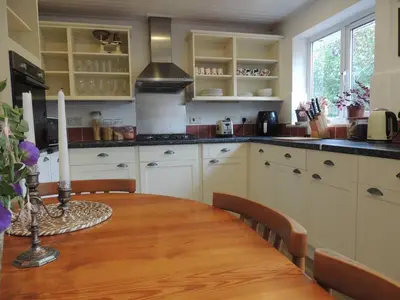 a kitchen with a wooden table with two candles on it at Oxencombe in Davidstow