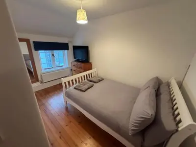 a small bedroom with a bed and a television at 3 Double Bed Character Cottage in Quiet Hamlet in Camelford