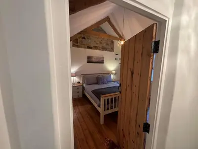 a small bedroom with a bed in an attic at 3 Double Bed Character Cottage in Quiet Hamlet in Camelford