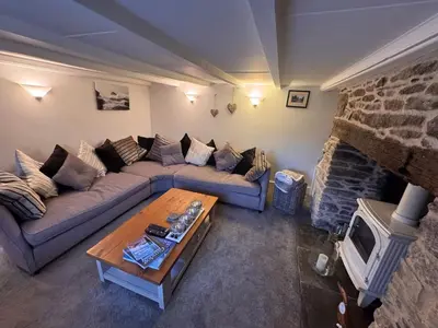 a living room with a couch and a fireplace at 3 Double Bed Character Cottage in Quiet Hamlet in Camelford