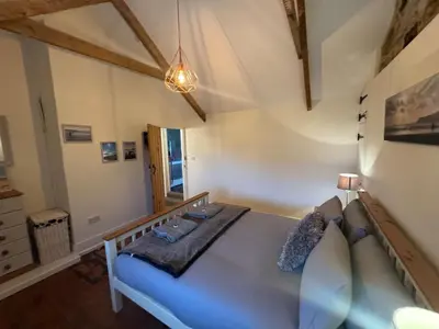 a bedroom with a large blue bed in a room at 3 Double Bed Character Cottage in Quiet Hamlet in Camelford