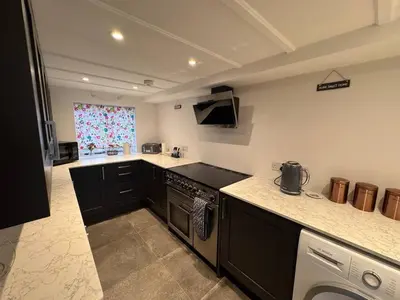 a kitchen with a stove and a counter top at 3 Double Bed Character Cottage in Quiet Hamlet in Camelford