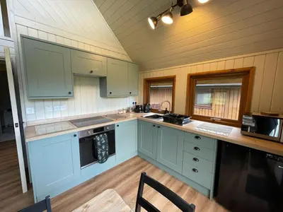 a kitchen with blue cabinets and a counter top at RoseTree Lodge 3 bed Sleeps 6 in Michaelstow