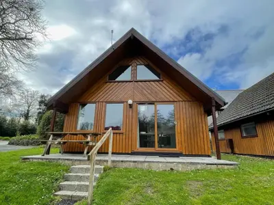 a small wooden house with a large window at RoseTree Lodge 3 bed Sleeps 6 in Michaelstow