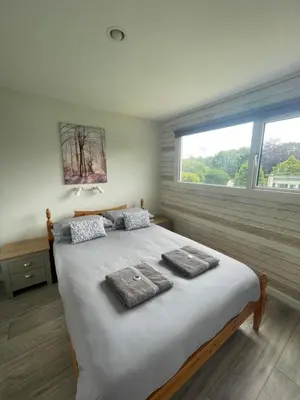 a bedroom with a large bed with towels on it at Villa 19 Lanteglos 2 bed sleep 5 in Lanteglos