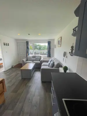 a living room with a couch and a table at Villa 19 Lanteglos 2 bed sleep 5 in Lanteglos