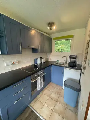 a kitchen with blue cabinets and a sink at Villa 19 Lanteglos 2 bed sleep 5 in Lanteglos