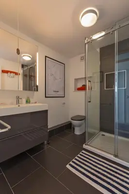 a bathroom with a shower and a sink and a toilet at Stunning Sea View Apartment in Falmouth