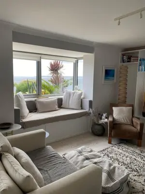a living room with a couch and a large window at Stunning Sea View Apartment in Falmouth