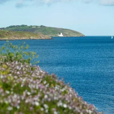 a large body of water with a house in the distance at Stunning Sea View Apartment in Falmouth