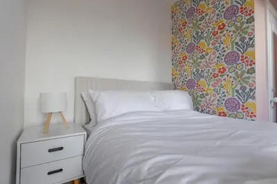 a bedroom with a white bed and a lamp on a night stand at Stylish 3-Bed Home - 2 Mins to Beach & Town in Falmouth