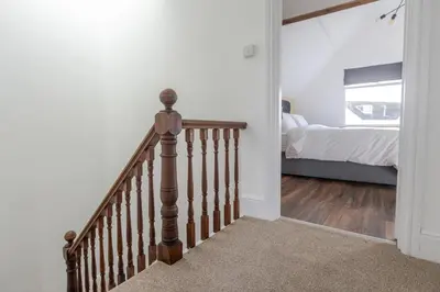 a stairway leading to a bedroom with a bed at Stylish 3-Bed Home - 2 Mins to Beach & Town in Falmouth