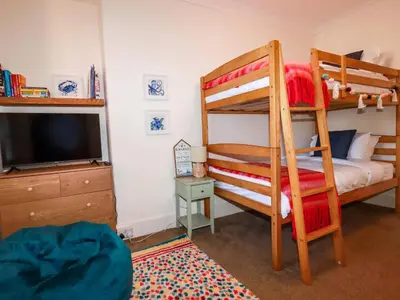 a bedroom with two bunk beds and a television at Chapel Cottage in St Austell