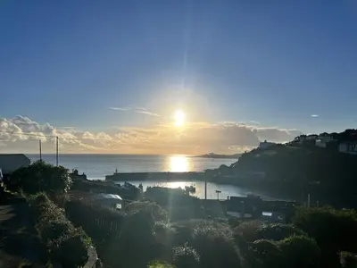 a view of the sun setting over the water at Chapel Cottage in St Austell