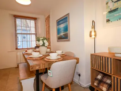 a dining room with a wooden table and chairs at Chapel Cottage in St Austell