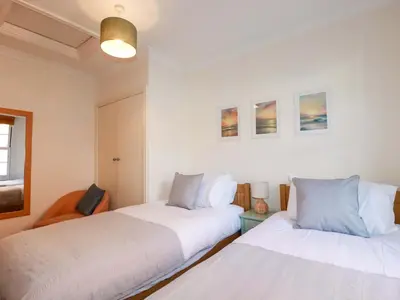 two beds sitting next to each other in a room at Chapel Cottage in St Austell