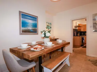 a dining room with a wooden table and chairs at Chapel Cottage in St Austell