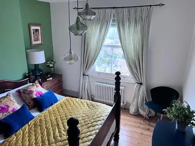 a bedroom with a bed with blue pillows and a window at Fimbarr's Reach in Fowey