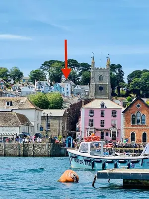 a dog laying in the water next to a boat at Fimbarr's Reach in Fowey