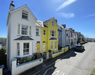 a row of yellow and white houses on a street at Fimbarr's Reach in Fowey