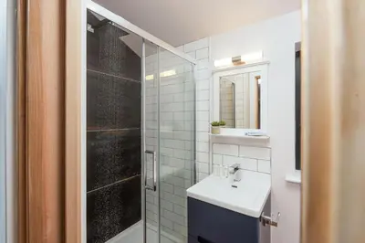 a white bathroom with a sink and a shower at Little Beachside in Newquay