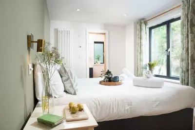 a bedroom with a large white bed with a window at Little Beachside in Newquay