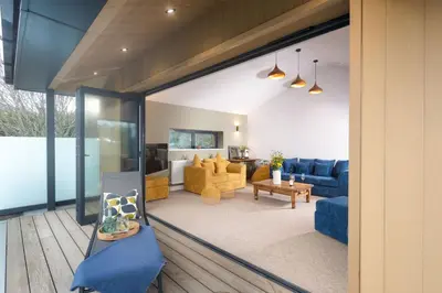 a living room with a blue couch and a table at Little Beachside in Newquay