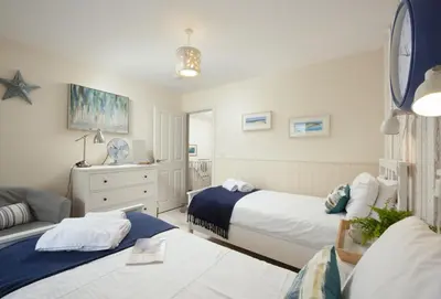 a bedroom with two beds and a couch at Little Puffin Way in Hayle