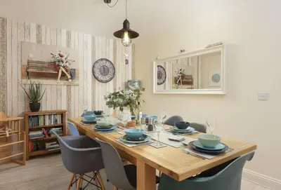 a dining room with a wooden table and chairs at Little Puffin Way in Hayle