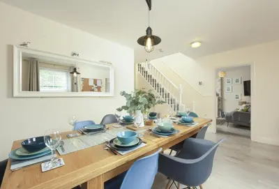 a dining room with a wooden table and chairs at Little Puffin Way in Hayle