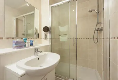 a bathroom with a sink and a glass shower at Little Puffin Way in Hayle