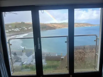a view of a rainbow from a window at Harbour Views, Coverack in Helston