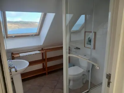 a bathroom with a toilet and a sink and a window at Harbour Views, Coverack in Helston