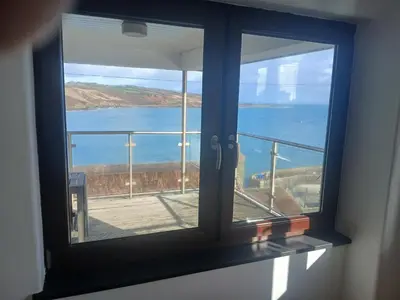a window with a view of a body of water at Harbour Views, Coverack in Helston