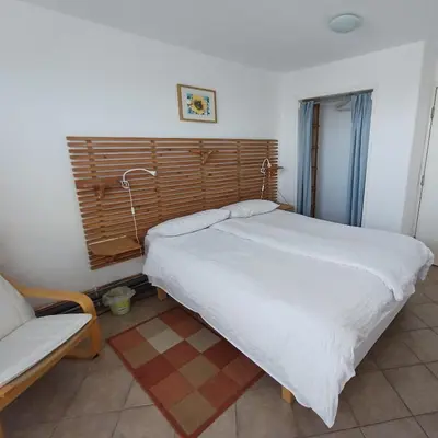 a bedroom with a large white bed and a couch at Harbour Views, Coverack in Helston