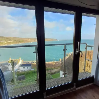 a view of the ocean from a room with windows at Harbour Views, Coverack in Helston