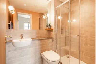 a bathroom with a shower and a toilet and a sink at Romantic and stylish retreat in Falmouth