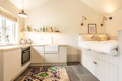 a small kitchen with a bed on top of it at Romantic and stylish retreat in Falmouth