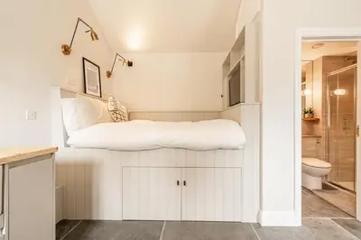 a bedroom with a bed in the corner of a room at Romantic and stylish retreat in Falmouth