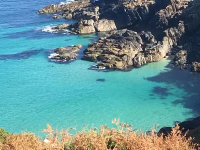 a view of a beach with rocks and blue water at The Little Barn Near St Ives Beaches & Walks, Dog Friendly in St Ives