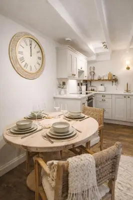 a dining room with a table and a clock on the wall at The Little Lobster in Porthleven